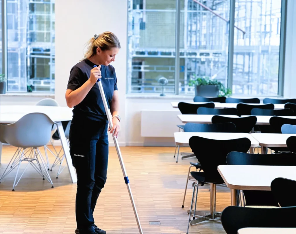 Medarbetare utför flyttstädning av kontorslokal med mop inför inflyttning